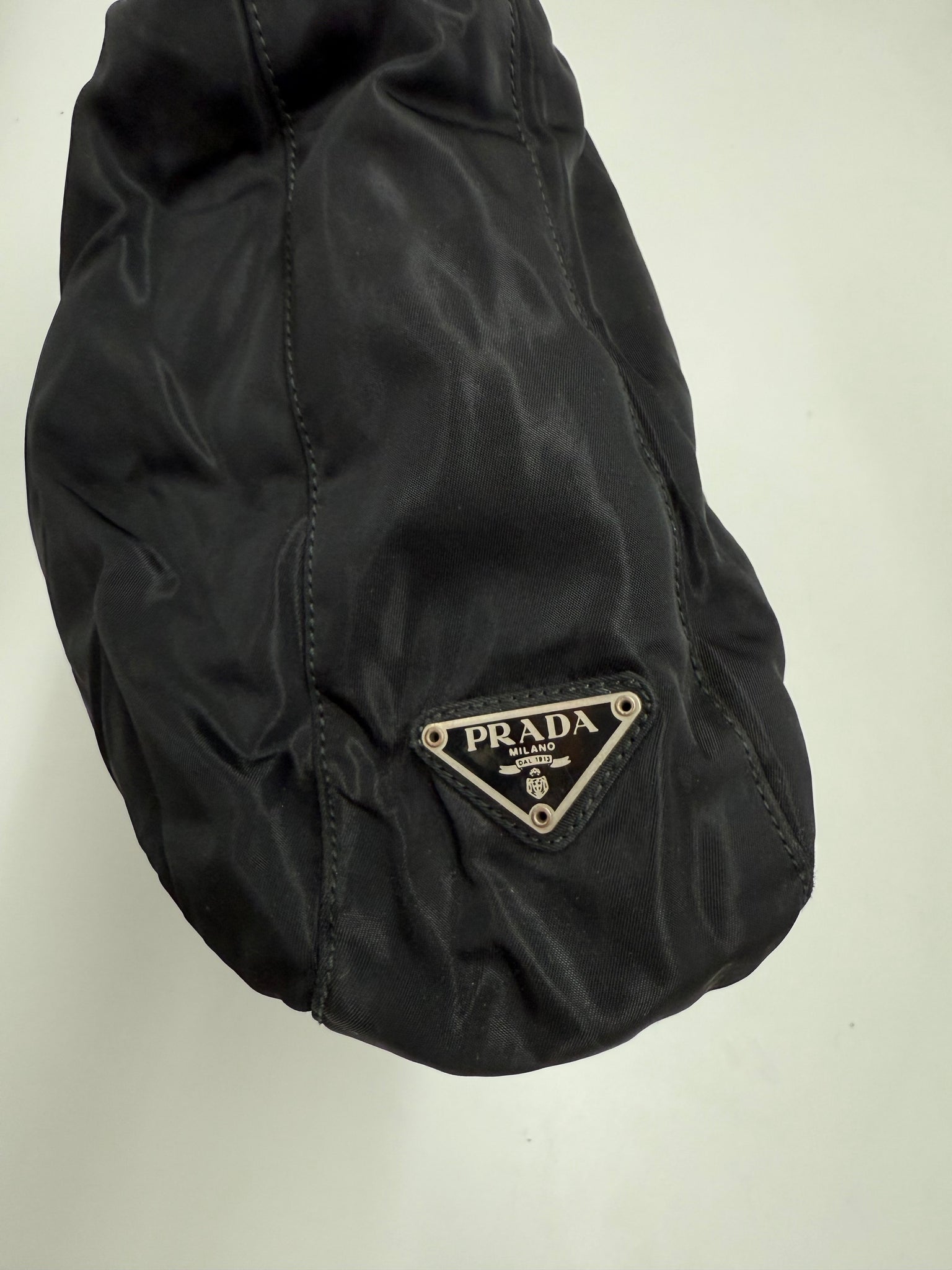 Black handbag on a light gray background Prada highend designer nylon luxury