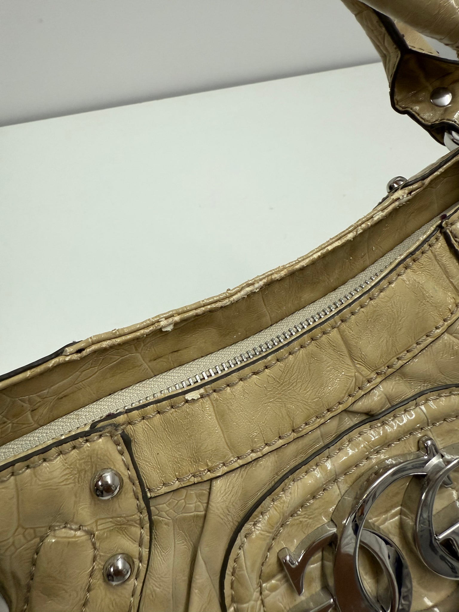 Vintage-style handbag with studded details on a white background Guess patten leather with silver hardware design Y2K grunge style