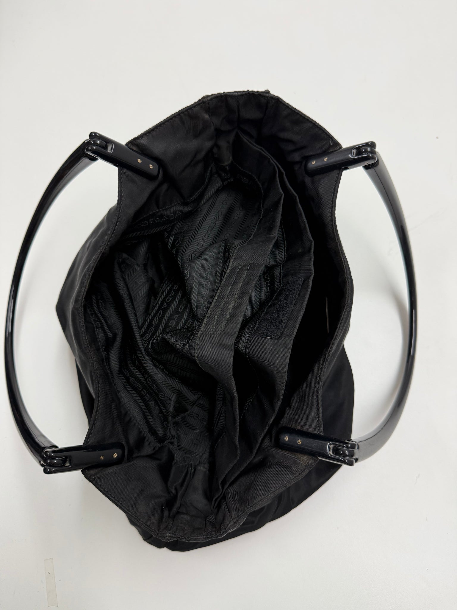 Black handbag on a light gray background Prada highend designer nylon luxury