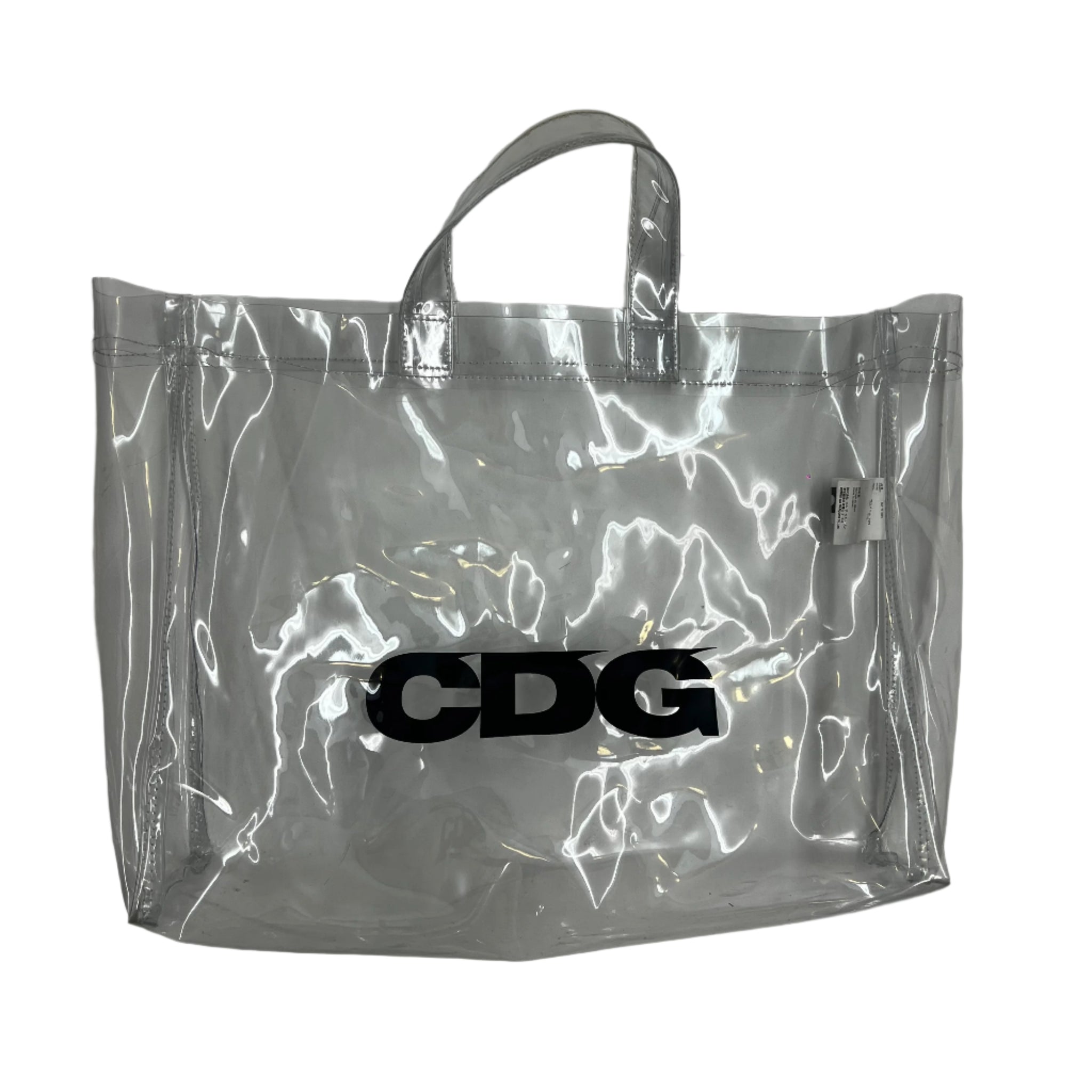 CDG clear PVC tote bag with bold logo print and reinforced handles. Stylish and practical statement piece