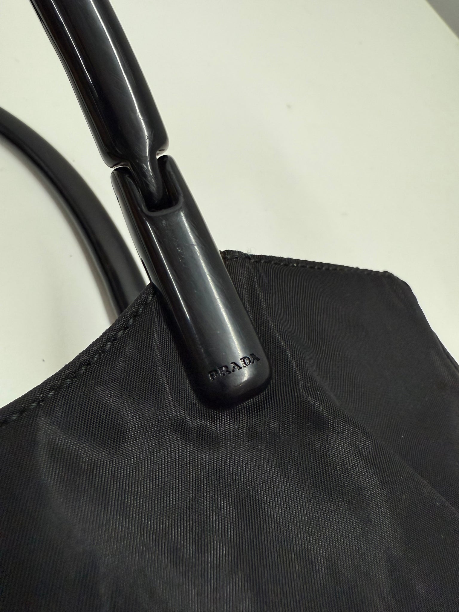 Black handbag on a light gray background Prada highend designer nylon luxury