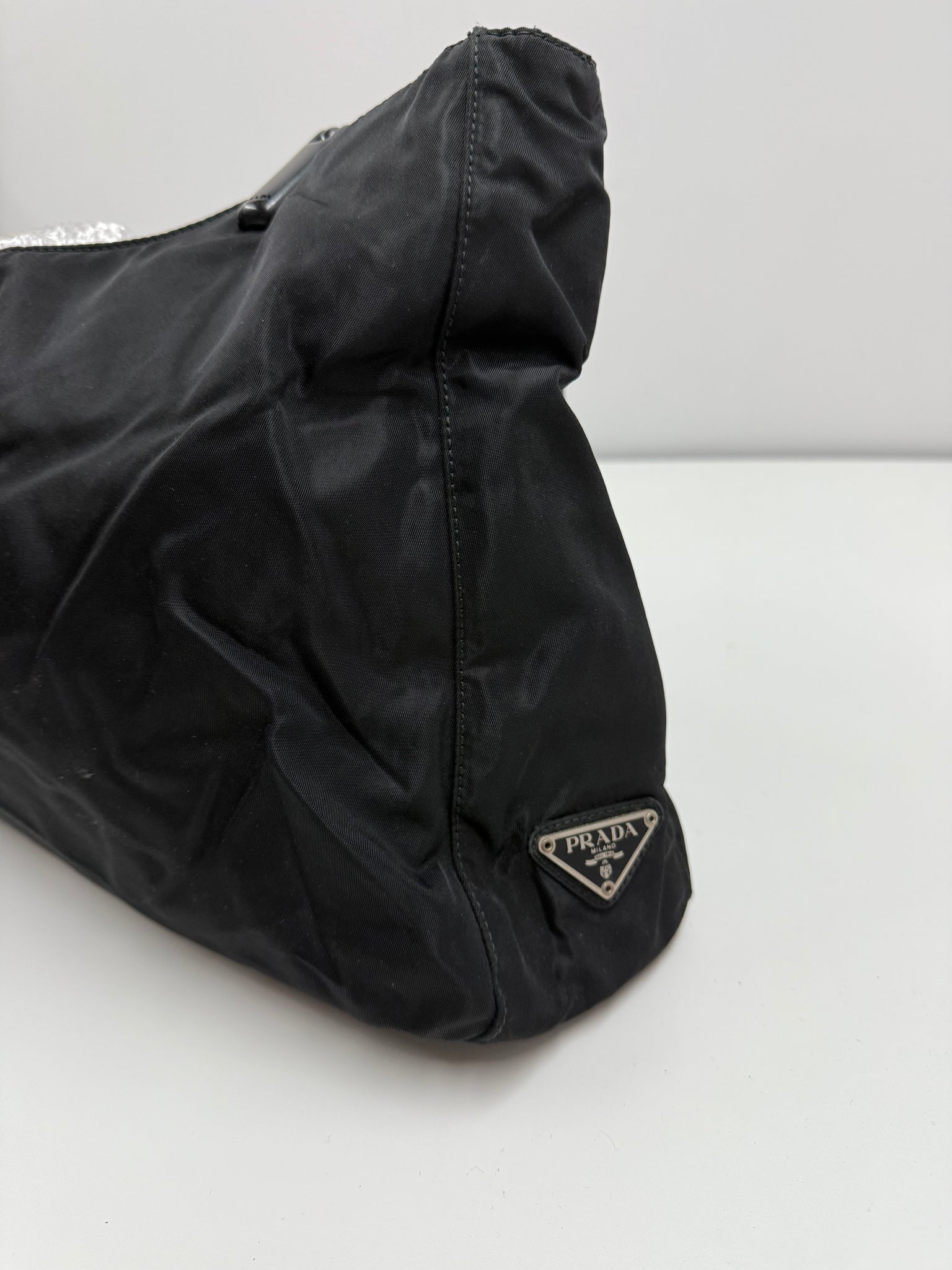 Black handbag on a light gray background Prada highend designer nylon luxury