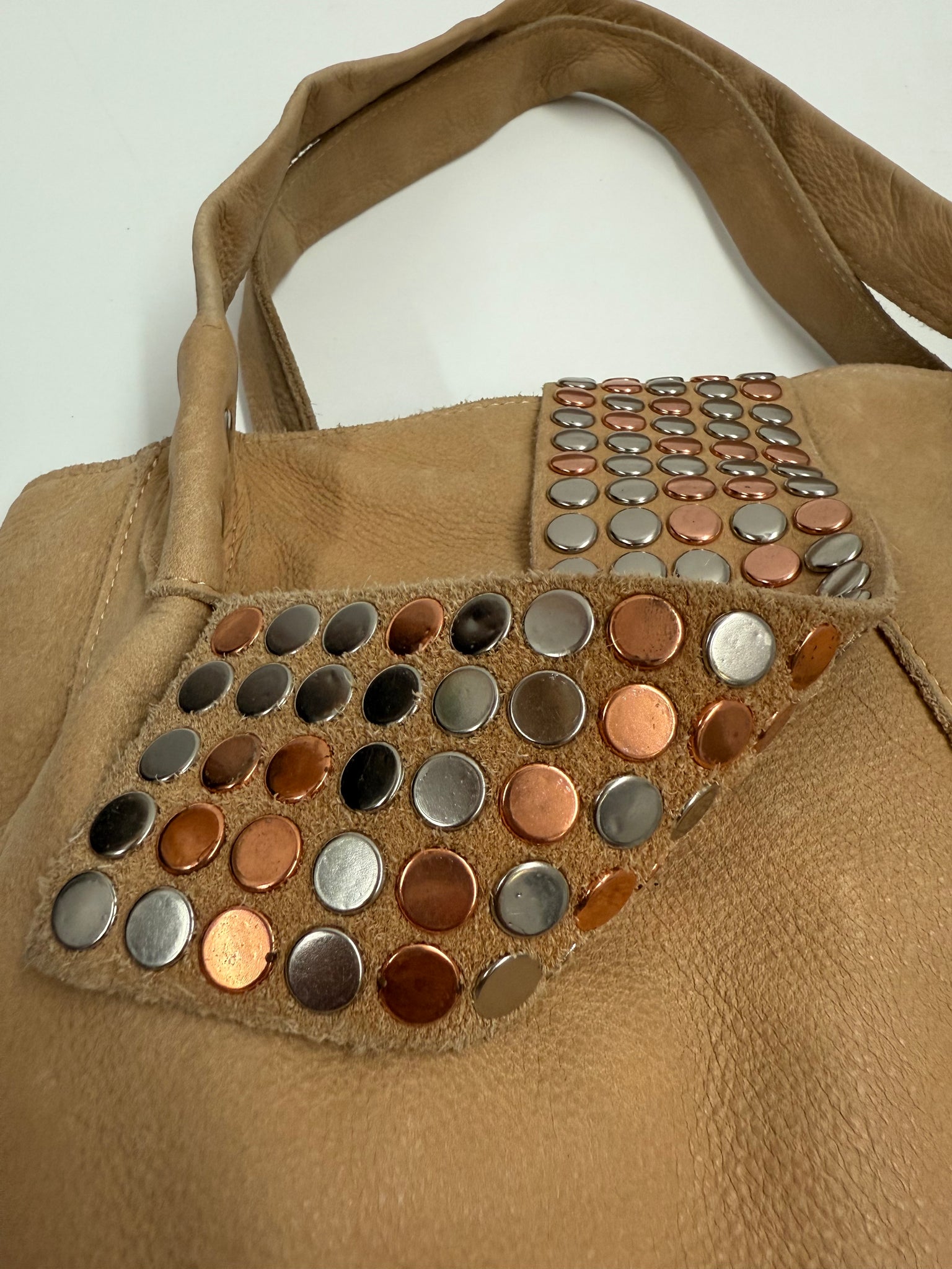 Brown leather bag with button embellishments on a white background