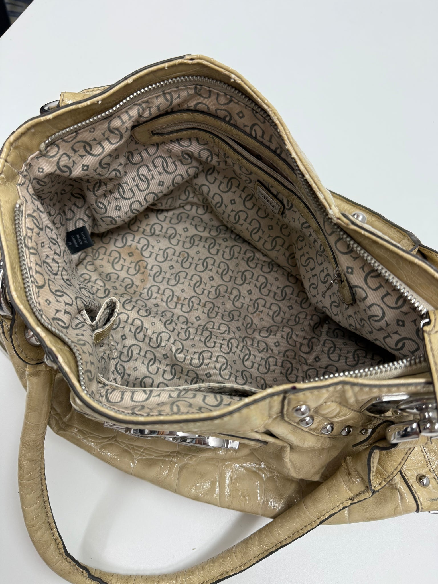 Vintage-style handbag with studded details on a white background Guess patten leather with silver hardware design Y2K grunge style