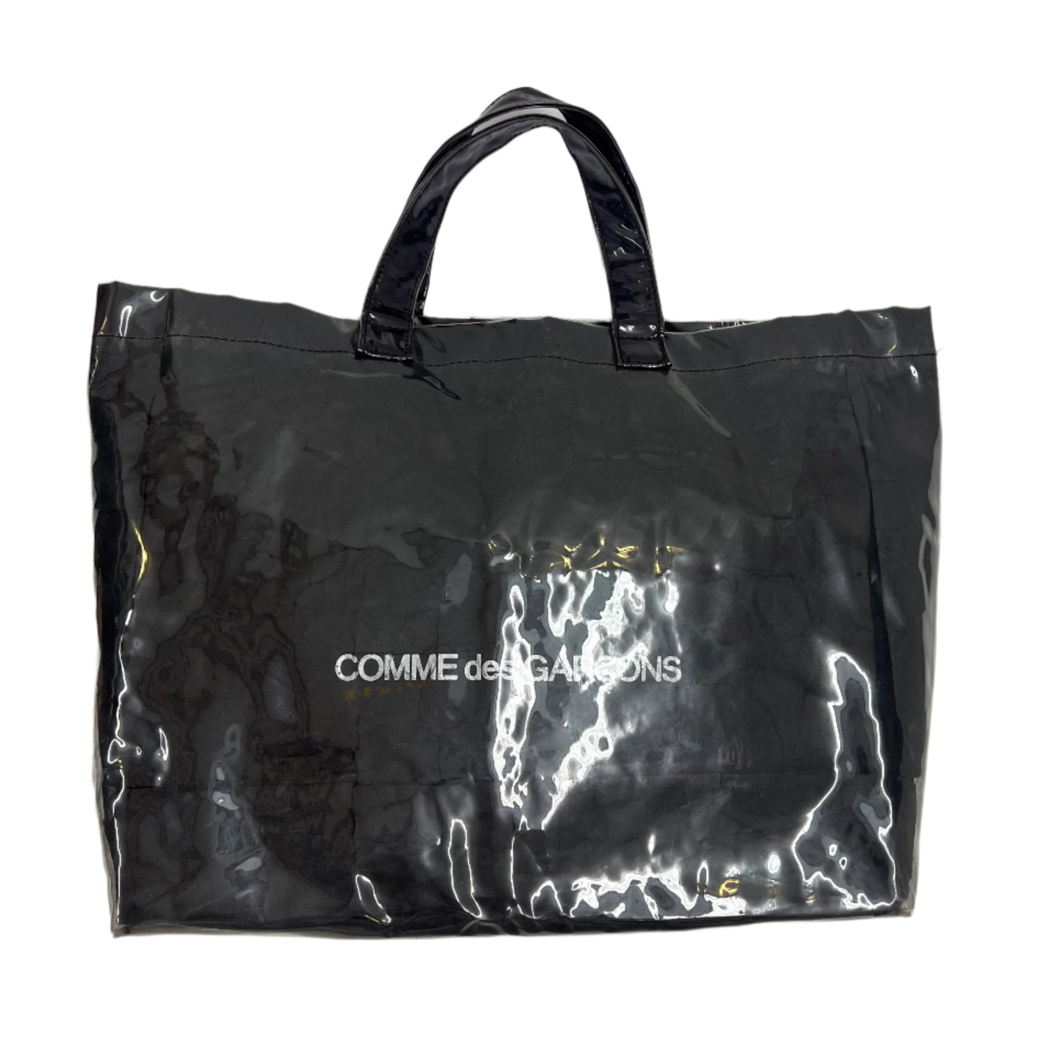 Comme des Garçons SHIRT PVC paper bag tote featuring transparent construction with soft, flexible material and minimalist design. Lightweight and modern accessory from the Japanese label.