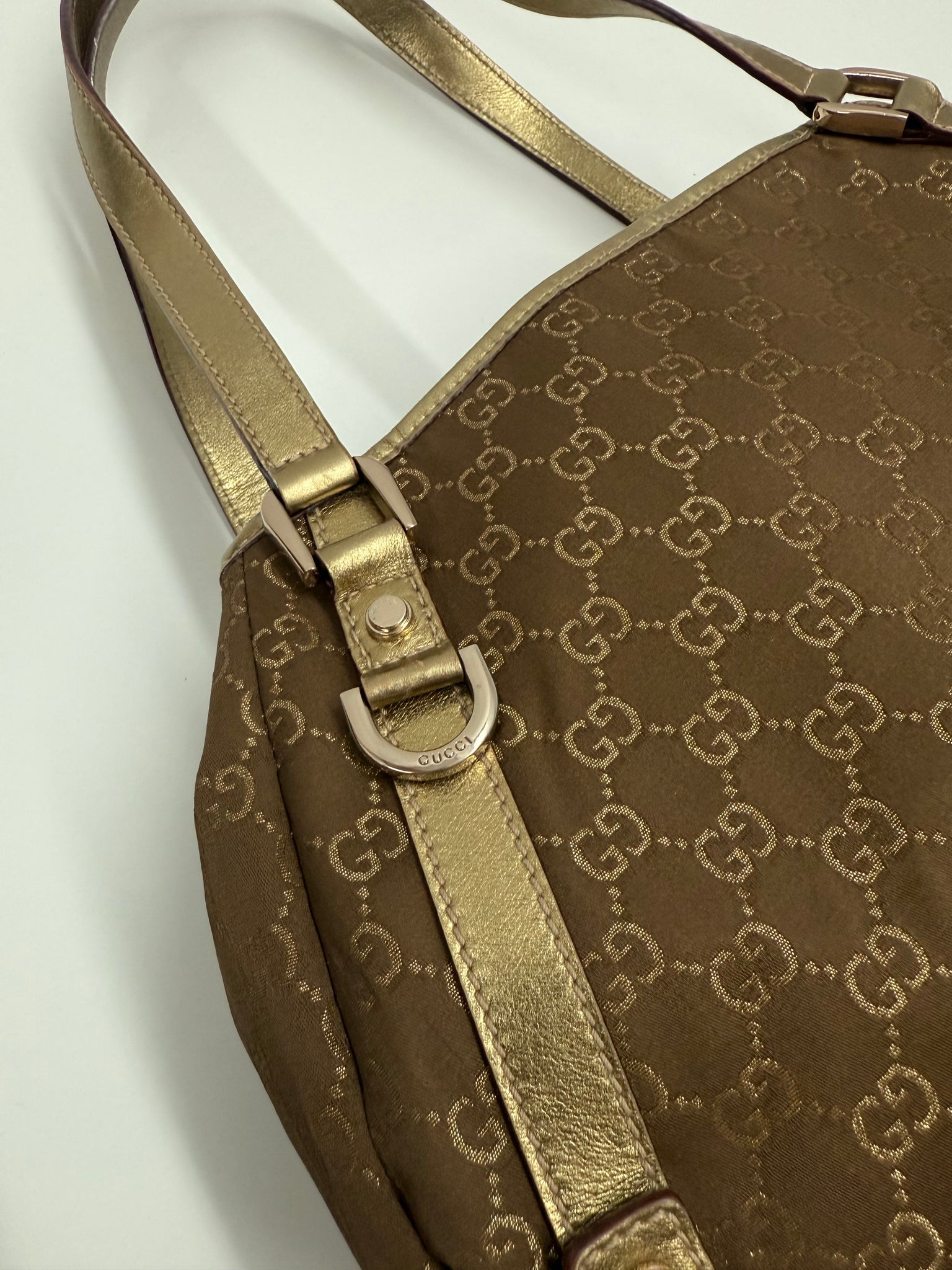 Brown patterned bag on a white background gucci hang bag gold design with iconic pattern high end designer luxury